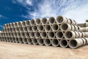 Stack of concrete drainage pipes for wells and water discharges with blue sky
