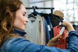 Woman looking at price tag of dress