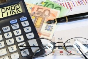 un calculator alături de o pereche de ochelari și bani