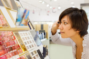 o femeie testeaza cosmetice intr-un magazin