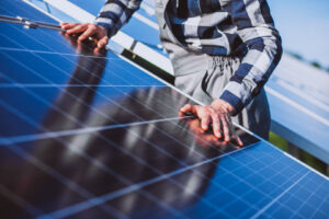 un lucrator instaleaza panouri fotovoltaice