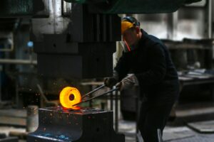 un barbat lucreaza intr-o fabrica