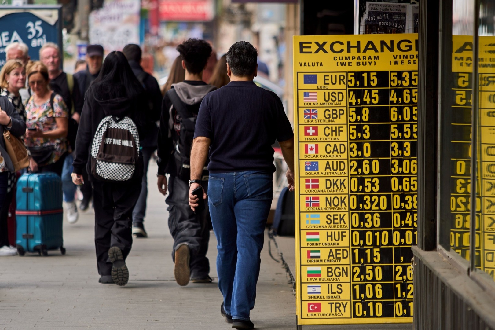 oameni pe stradă în bucurești trec pe lângă un exchange