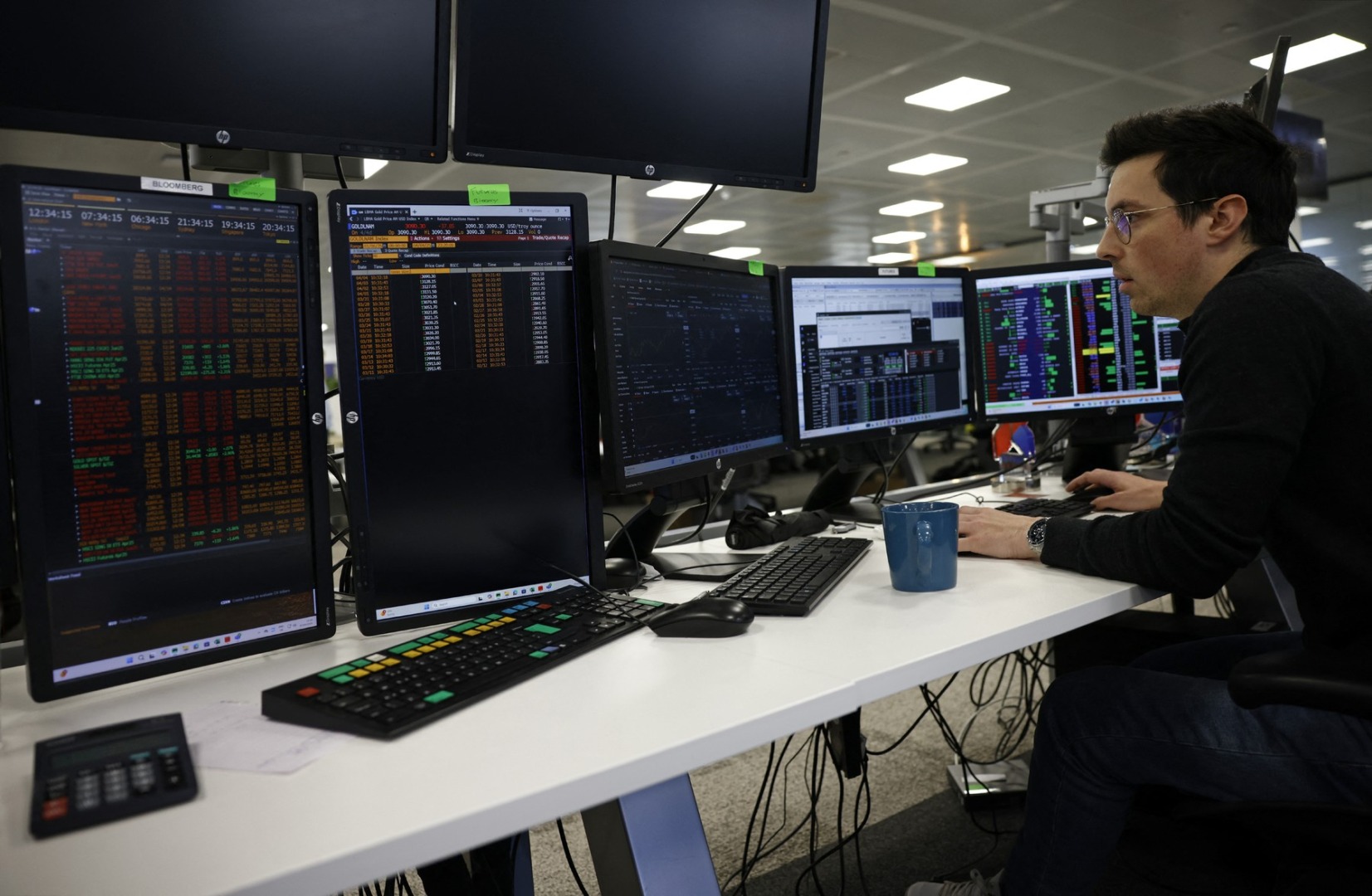 un trader se uita la un terminal bloomberg