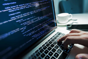 un programator lucreaza la un laptop