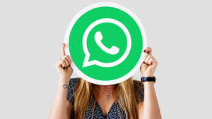 o femeie isi acopera fata cu un carton cu sigla whatsapp